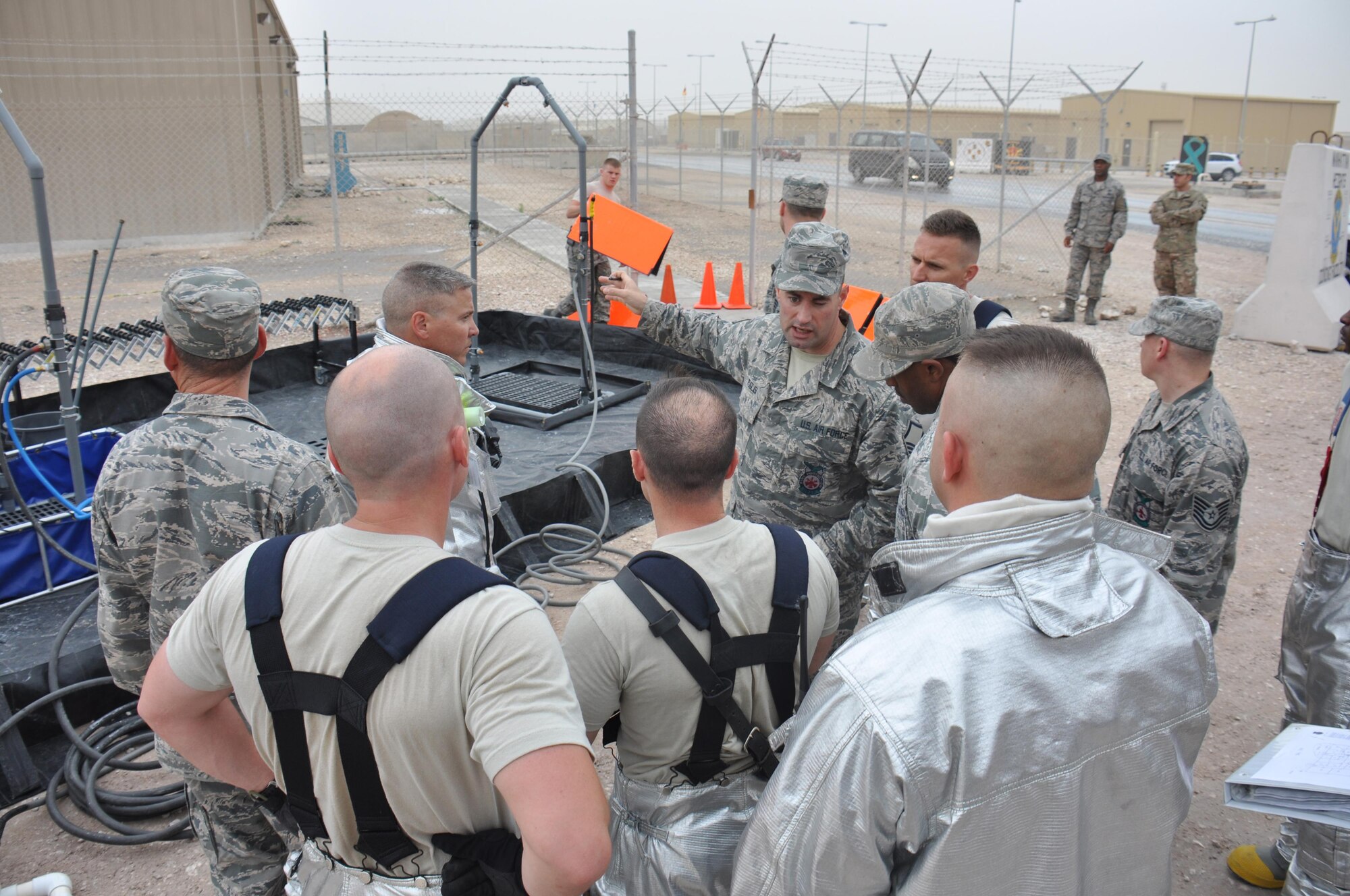 Master Sgt. Michael Puglisi, 379th Expeditionary Civil Engineer Squadron assistant fire chief of operations, gives instructions to firefighters during a hazardous materials exercise at Al Udeid Air Base, Qatar March 16. Puglisi served as the incident commander for the exercise, which featured mock explosives and chemicals. The exercise provided first responders an opportunity to practice reacting to an emergency incident. Several emergency personnel participated in the exercise including security forces and medics. (U.S. Air Force photo by Tech. Sgt. James Hodgman/Released)