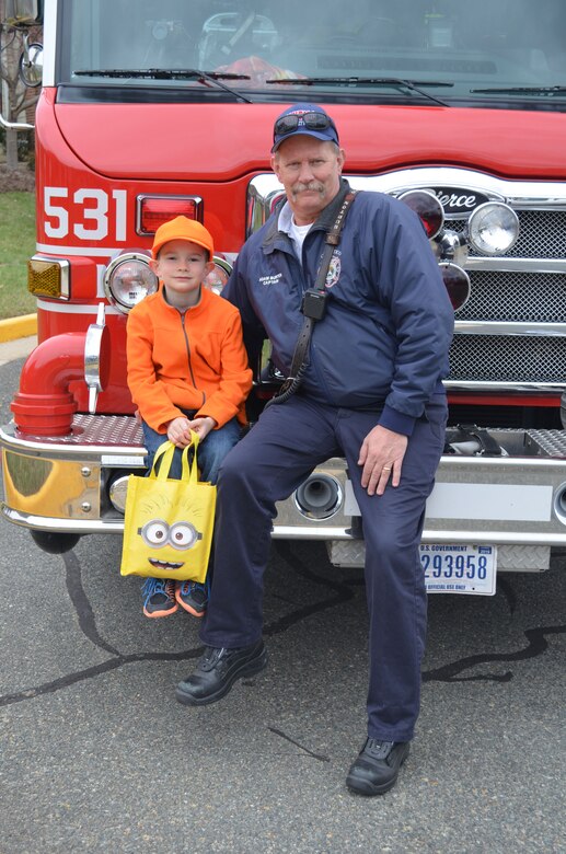 MARINE CORPS BASE QUANTICO, Va. — Marine Corps Base Quantico firefighter Adam Burton, of station 531, and his son Tucker, 8, take a quick break by a fire truck during the 2016 Easter Egg Hunt held at the Lincoln Military Housing office.