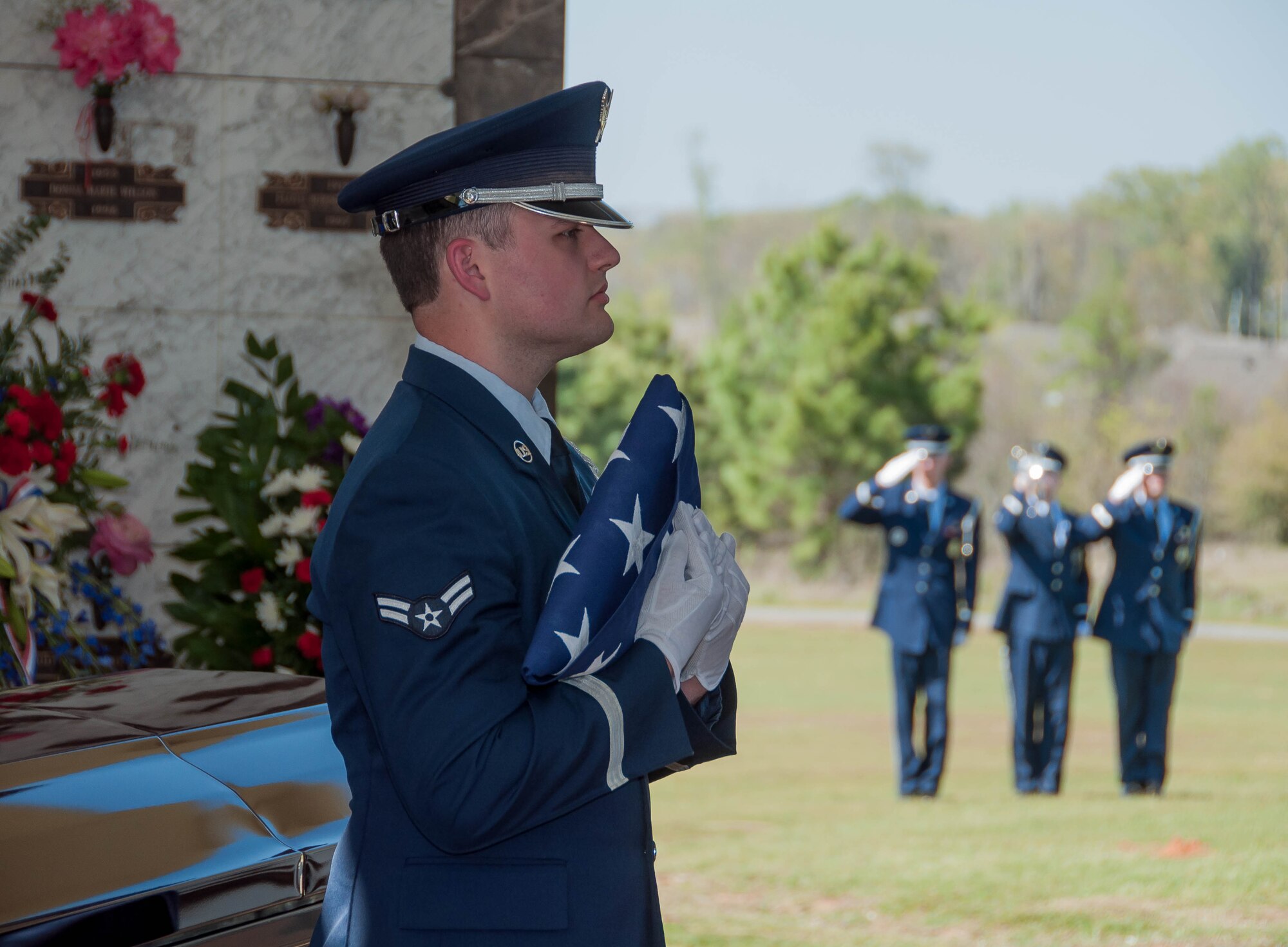 A member of the Barksdale Air Force Base Honor Guard holds a folded American flag while taps is played during the funeral service for Retired Master Sgt. Chief Layton Wehling on March 22, 2016 at Hillcrest Cemetery in Bossier City, La. Wehling, worked as a civilian in the 307th Civil Engineer Squadron and was known as “The Chief” to the many he mentored and served with. (U.S. Air Force photo by Master Sgt. Laura Siebert/Released)