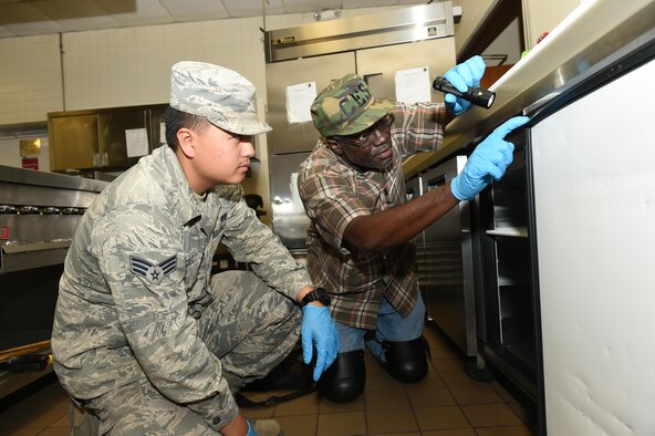 97th Civil Engineer Squadron Pest Management specialists inspect common hiding spots for insects in the Club Altus kitchen, Altus Air Force Base, Okla., March 24, 2016. Pest management specialist inspect all food facilities on base once a month to manage pest populations and keep Airmen safe. (U.S. Air Force photo by Airman 1st Class Kirby Turbak/Released)