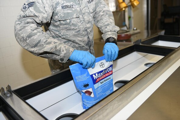 97th Civil Engineer Squadron Pest Management specialist closes a bag of bait stations in the Club Altus kitchen, Altus Air Force Base, Okla., March 24, 2016. Pest management specialist inspect all food facilities on base once a month to manage pest populations and keep Airmen safe. (U.S. Air Force photo by Airman 1st Class Kirby Turbak/Released)