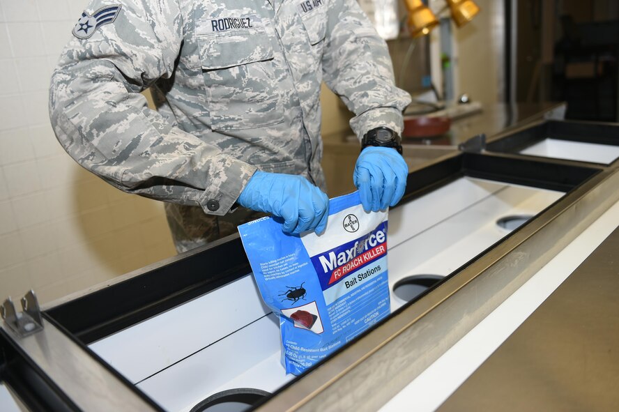 97th Civil Engineer Squadron Pest Management specialist closes a bag of bait stations in the Club Altus kitchen, Altus Air Force Base, Okla., March 24, 2016. Pest management specialist inspect all food facilities on base once a month to manage pest populations and keep Airmen safe. (U.S. Air Force photo by Airman 1st Class Kirby Turbak/Released)