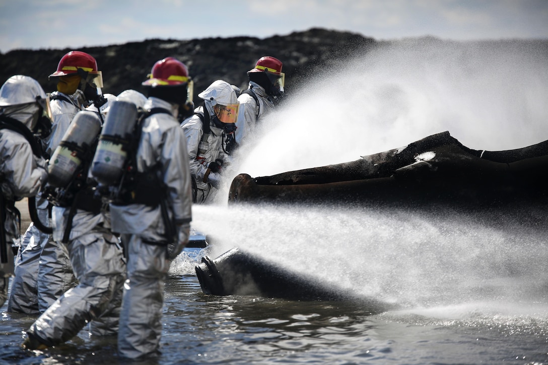 Marines use fire hoses to extinguish a blaze during firefighting training to sharpen their skills at Marine Corps Air Station Iwakuni, Japan, March 11, 2016. Marine Corps photo by Lance Cpl. Jacob A. Farbo