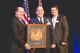 Col. James Dignan (center) accepts the Youngstown-Warren Regional Chamber’s Spirit of The Valley Award from Chamber President & CEO Thomas Humphries (left), and Farmers National Bank President & CEO Kevin Helmick (right) during the group’s Annual Meeting held here, March 23, 2016. Dignan received the award for exemplary leadership and commitment to the community, economic development and the overall progress of the Mahoning Valley and is commander of the 910th Airlift Wing based at nearby Youngstown Air Reserve Station, Ohio. (Courtesy Photo/Ms. Leslie Cusano,Youngstown-Warren Regional Chamber)
