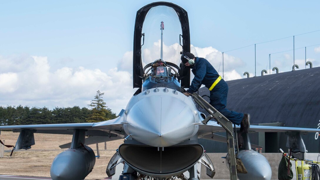 U.S. Air Force Airman Joseph Farmer, a crew chief with the 35th Maintenance Squadron, helps secure Lt. Col. Paul Miller, the deputy commander of the 35th Operations Group, into an F-16 Fighting Falcon during exercise Beverly Sunrise 16-03 at Misawa Air Base, Japan, March 23, 2016. Before and after flight, crew chiefs perform inspections, ensuring a safe flight for the pilot. (U.S. Air Force photo by Airman 1st Class Jordyn Fetter)