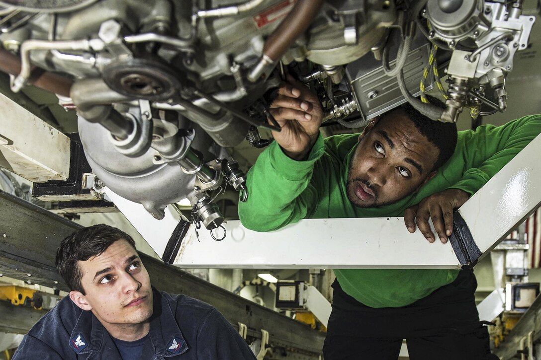 Navy Petty Officer 3rd Class Austin Prim and Airman Rodney Mahone connect oil lines on an aircraft engine aboard the USS Dwight D. Eisenhower in the Atlantic Ocean, March 23, 2016. The aircraft carrier is conducting a Composite Training Unit Exercise to prepare for a future deployment. Navy photo by Seaman Casey J. Hopkins