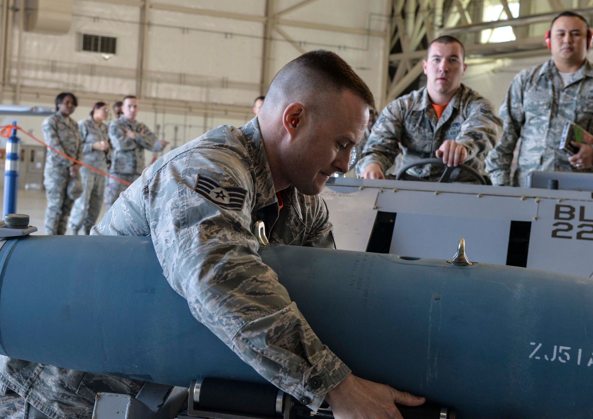 Staff Sgt. Justin, 432nd AMXS weapons load crew chief, loads a bomb onto the aircraft during the 2015 Load Crew of the Year competition March 10, 2016 at Creech Air Force Base, Nevada. Justin is in charge of Airman 1st Class Stuart and Senior Airman Christopher, both 432nd AMXS weapons load crew members.