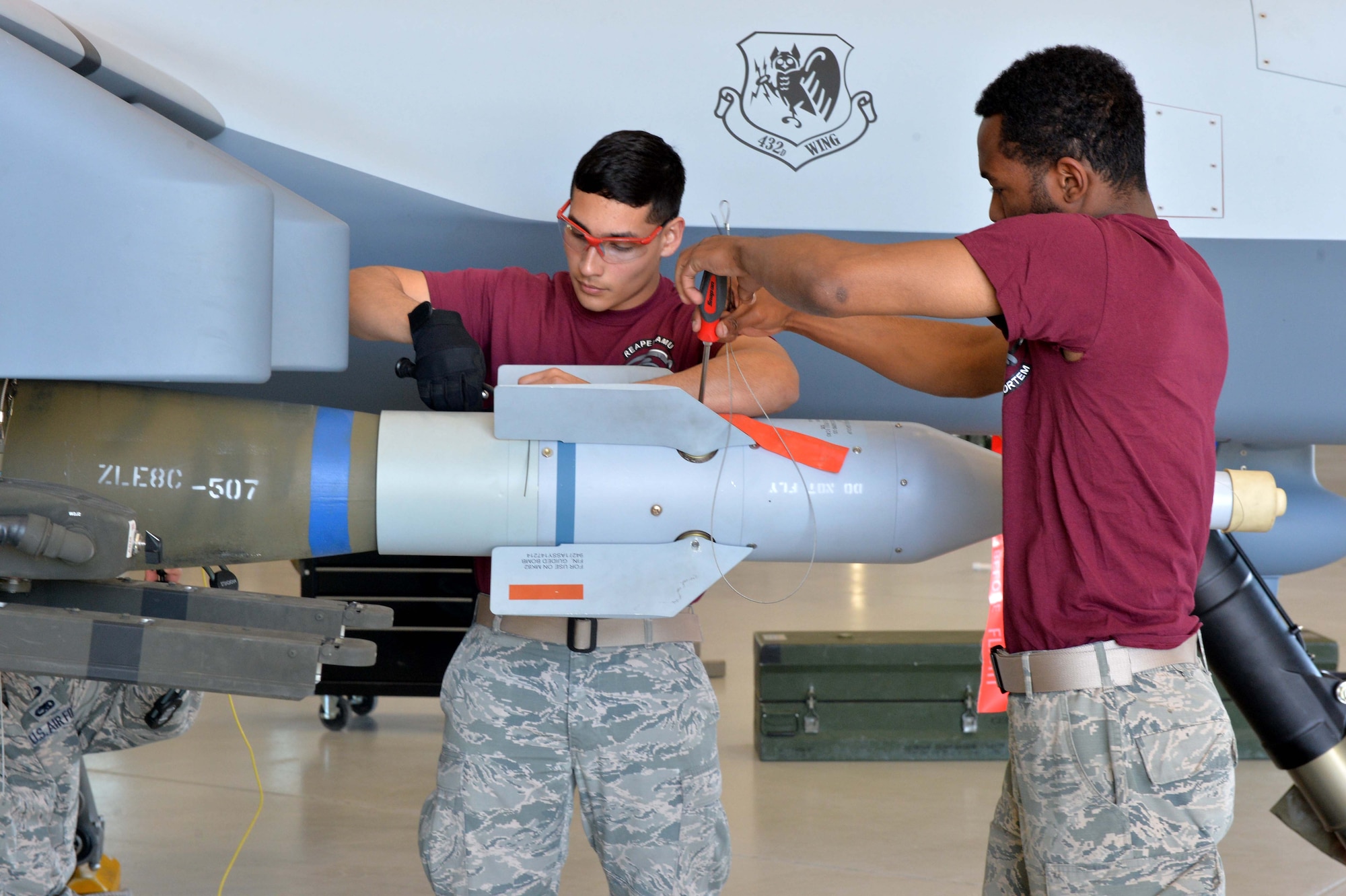 Airman 1st Class Quantavious and Airman 1st Class Ricardo, both 432nd Aircraft Maintenance Squadron weapons load crew members, performs maintenance during the 2015 Load Crew of the Year competition March 9, 2016, at Creech Air Force Base, Nevada. Quantavious and Ricardo were selected to represent Reaper Aircraft Maintenance Unit at the competition. (U.S Air Force photo by Airman 1st Class Kristan Campbell/Released)