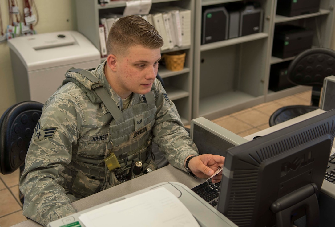 U.S. Air Force Senior Airman Brandon Johnson, 7th Security Forces Squadron visitor control center clerk, processes a base pass, March 23, 2016, at Dyess Air Force Base, Texas. Security forces processed more than 72,000 visitors in 2015. These Airmen have the responsibility to defend Dyess personnel and assets. (U.S. Air Force photo by Airman 1st Class Austin Mayfield/Released)