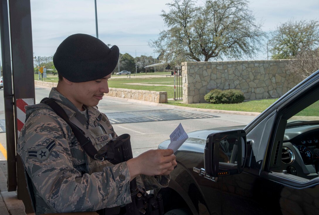 U.S. Air Force Airman 1st Class Brandon Melencio, 7th Security Forces Squadron member, checks a visitor’s pass at the Arnold Gate, March 22, 2016, at Dyess Air Force Base, Texas.  The 7th SFS recently won the Air Force Global Strike Command award for best medium security forces unit. 7th SFS improved the base identification process, which saved the Air Force annually more than $1 million and 240 man-hours.  (U.S. Air Force photo by Airman 1st Class Austin Mayfield/Released)