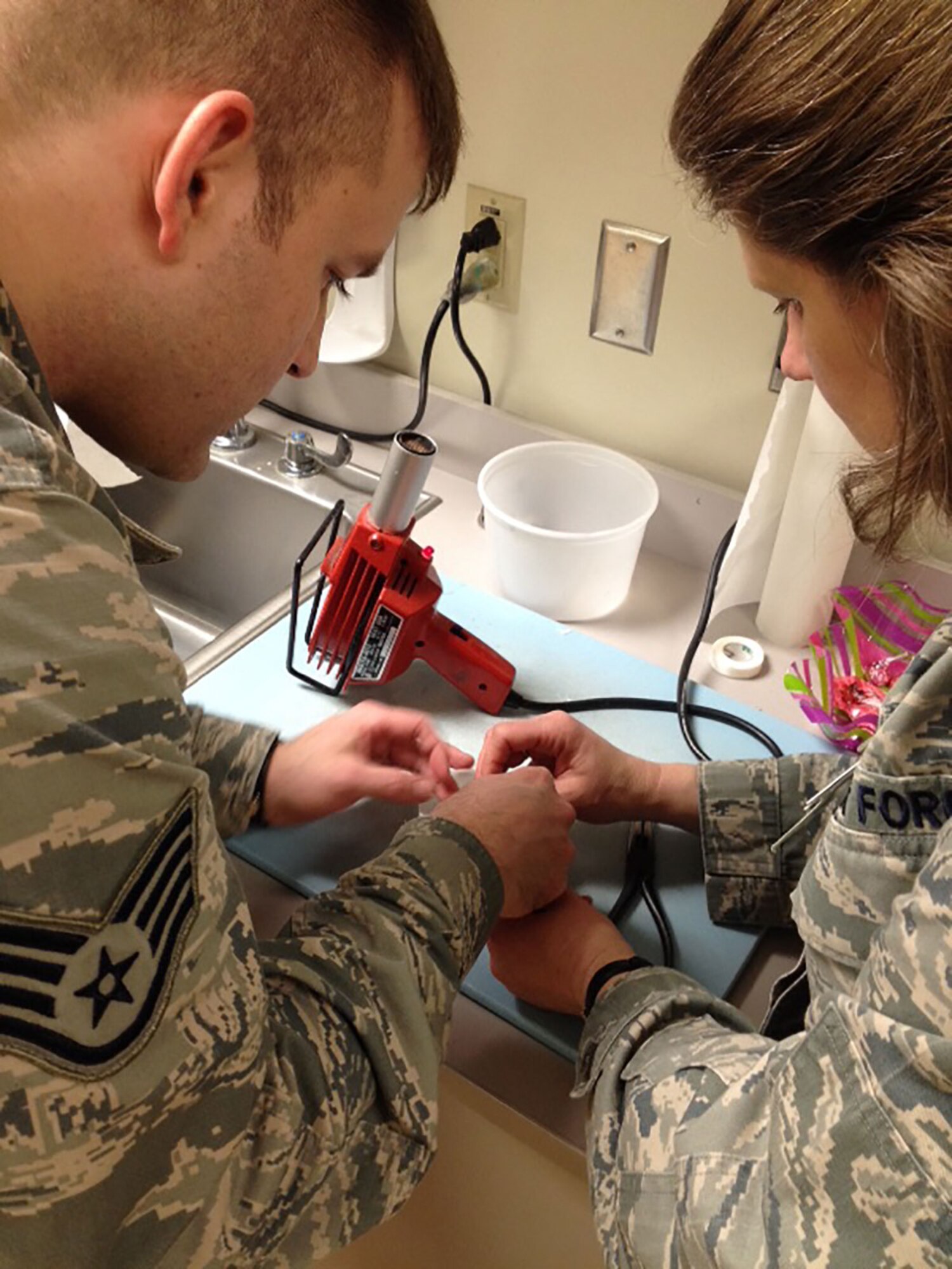 Air Force Lt. Col. Diana Medina (right), 673d Medical Operations Squadron Physical Occupational Therapy Flight commander, and Air Force Staff Sgt. Devin Rudd, 673d MDOS physical medicine technician, create a dynamic splint together at the Joint Base Elmendorf-Richardson hospital Feb. 26, 2016. The splint was for Air Force Master Sgt. Robert Wagner, 773d Civil Engineer Squadron primary security manager, after he injured his right hand middle finger while playing intramural soccer as a goalie. (Courtesy Photo)