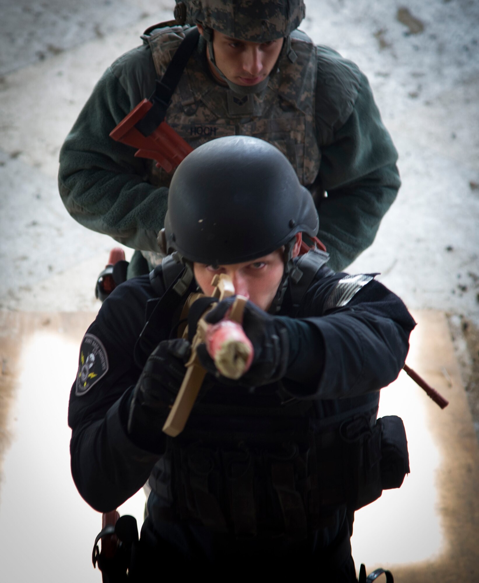 Senior Airman William Schuld, 11th Security Forces Squadron Emergency Services Team operator (front),  and Senior Airman David Hoch, 11th Security Forces Squadron response force leader, enter a house during the Tactical Combatives Course, a class ran by the U.S. Army Combatives School, March 22, 2016. Any service member who wishes to participate in the course just needs to provide their most recent physical fitness assessment, fill out a safety questionnaire, and complete a combatives injury screening form. (U.S. Air Force photo by Senior Airman Mariah Haddenham/released)