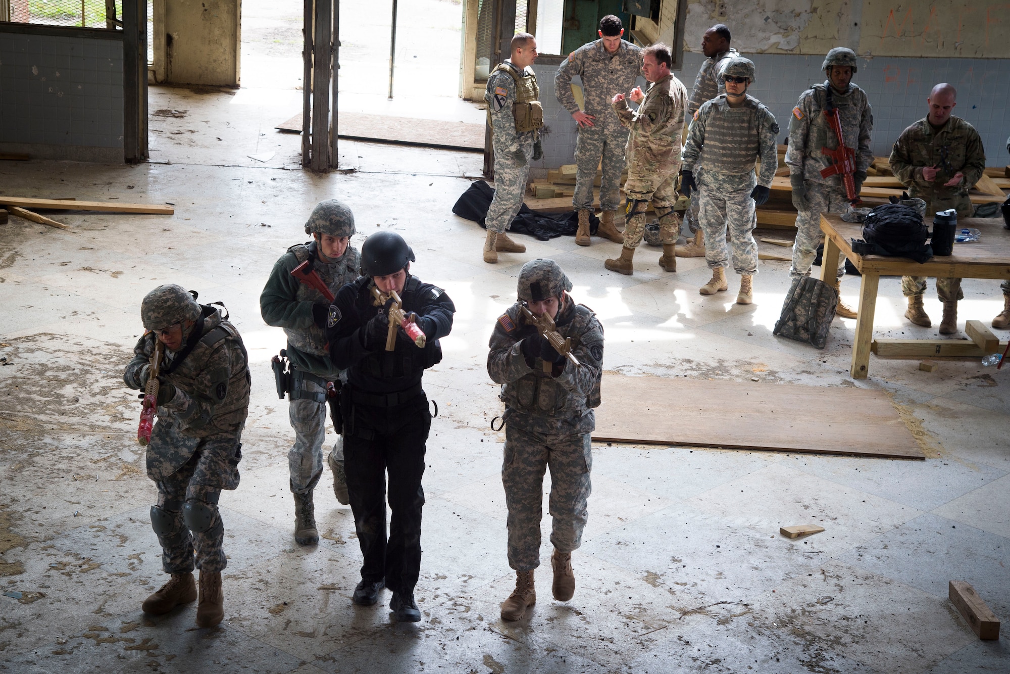 Service members prepare to clear a room as their teammates look on at the Tactical Combatives Course; a class ran by the U.S. Army Combatives School, March 22, 2016. Any service member who wishes to participate in the course just needs to provide their most recent physical fitness assessment, fill out a safety questionnaire, and complete a combatives injury screening form. (U.S. Air Force photo by Senior Airman Mariah Haddenham/released)