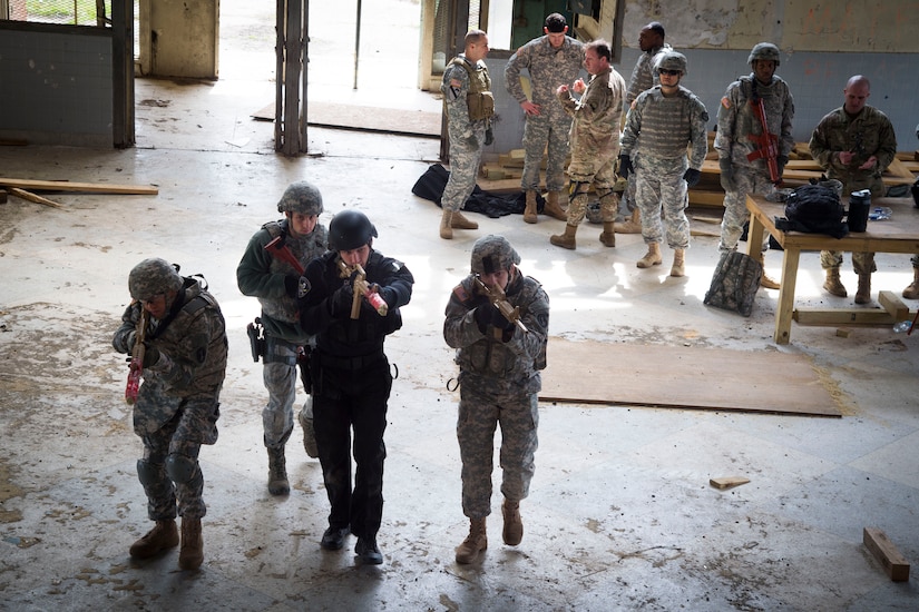 Service members prepare to clear a room as their teammates look on at the Tactical Combatives Course; a class ran by the U.S. Army Combatives School, March 22, 2016. Any service member who wishes to participate in the course just needs to provide their most recent physical fitness assessment, fill out a safety questionnaire, and complete a combatives injury screening form. (U.S. Air Force photo by Senior Airman Mariah Haddenham/released)