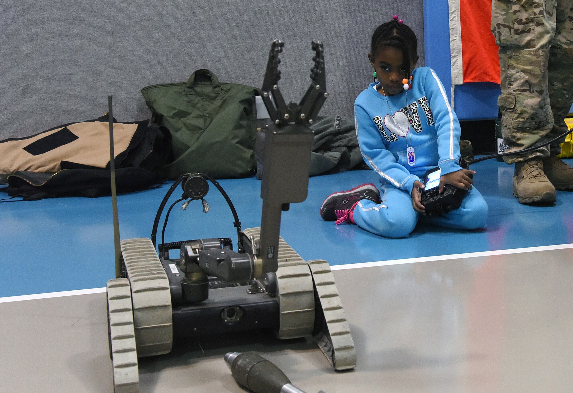 Isys,6, daughter of Tech Sgt. Gary King, 341st Civil Engineer Squadron water and fuels system maintenance technician, and Tech Sgt. Felicia King, 490th Missile Squadron NCO in charge of aviation resource management, plays with a deployment robot, I-Robot 310, at a junior deployment line March 23, 2016, at Malmstrom Air Force Base, Mont. The 341st Force Support Squadron hosted the event to give children a chance to see what their parents go through before deploying. (U.S. Air Force photo/Senior Airman Jaeda Tookes) 