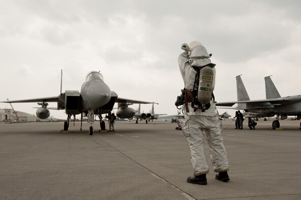 U.S. Air Force Senior Airman Patrick Walsh, 18th Civil Engineer Squadron firefighter, conducts aircraft barrier recovery training with a Japan Air Self-Defense Force F-15 Eagle fighter pilot assigned to the 9th Wing March 15, 2016, at Naha Air Base, Japan. USAF and JASDF partners overcame their language barriers by communicating through universal hand signals in compliance with NATO standardizations. (U.S. Air Force photo by Senior Airman Peter Reft)