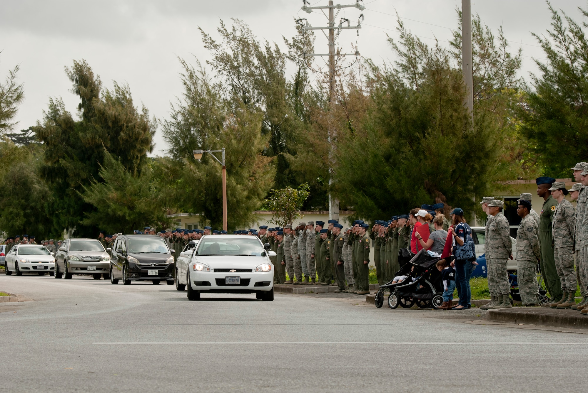 Team Kadena members salute commanders escorting family members of recently departed Jack Oshiro during a memorial procession March 18, 2016, at Kadena Air Base, Japan. Mr. Oshiro's 60 years of contributions to Kadena's history earned him much respect across the base. (U.S. Air Force photo by Senior Airman Peter Reft)