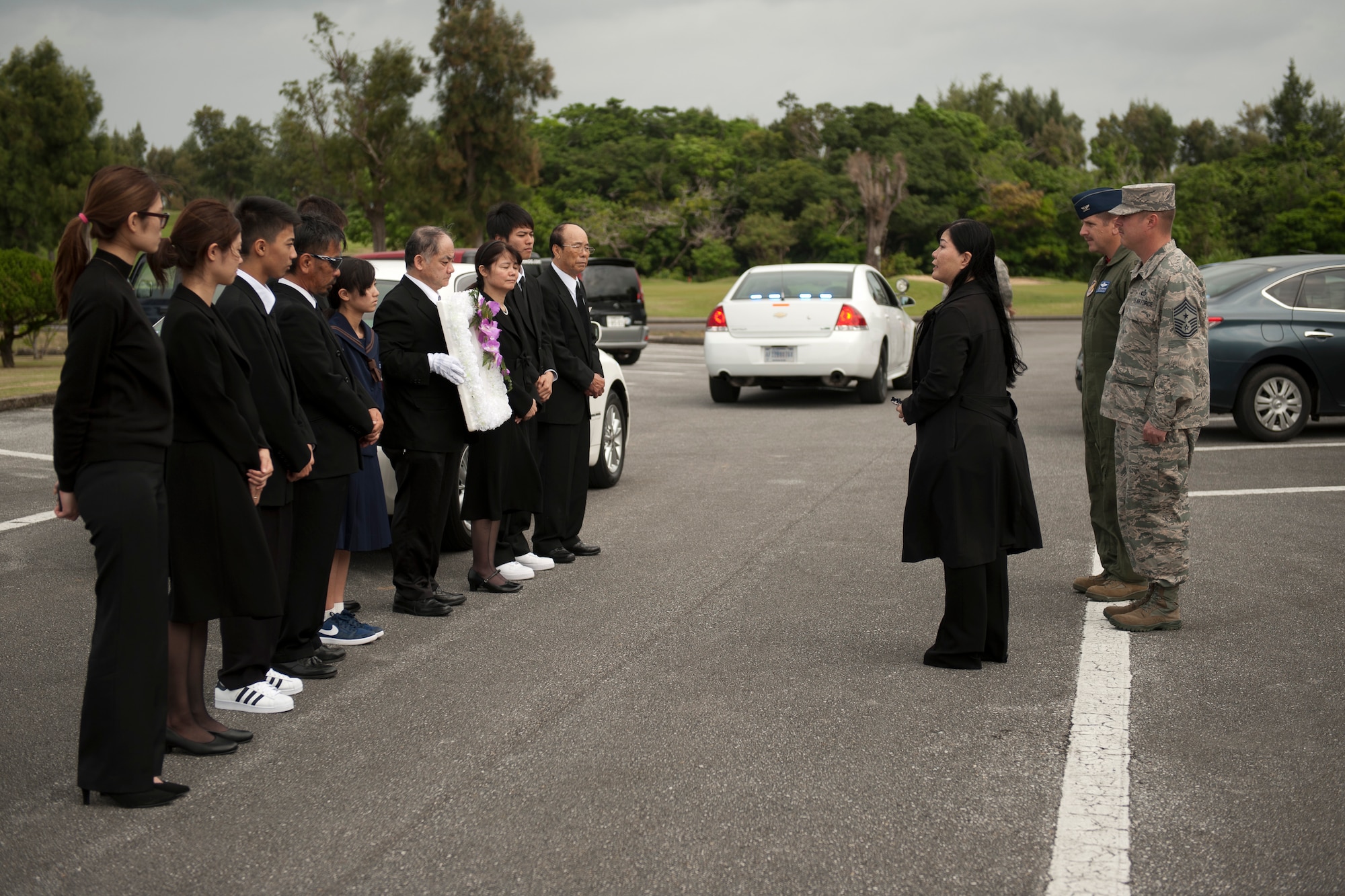 Family members of Jack Oshiro meet with U.S. Air Force Col. Christopher Amrhein, 18th Wing vice commander, and Chief Master Sgt. Charles Hoffman, 18th Wing command chief master sergeant, during a memorial procession March 18, 2016, at Kadena Air Base, Japan. Amrhein and Hoffman expressed their gratitude for Mr. Oshiro's many years of contributions to the Kadena community. (U.S. Air Force photo by Senior Airman Peter Reft)