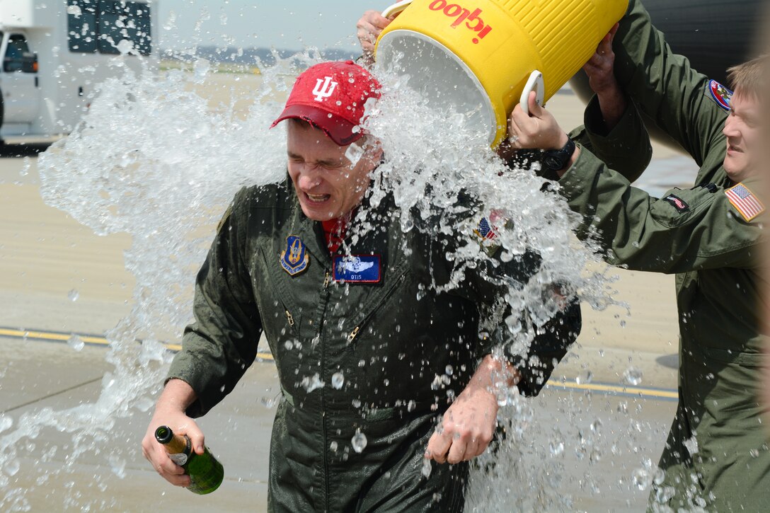 U.S. Air Force Col. Robert Oates, commander of the Advanced Airlift Tactics Training Center, gets doused with water after his fini flight at Rosecrans Air National Guard Base, St. Joseph, Mo., March 25, 2016. Oate’s fini flight marks the end of his 27 years of military service. (U.S. Air National Guard photo by Tech. Sgt. Michael Crane/Released))