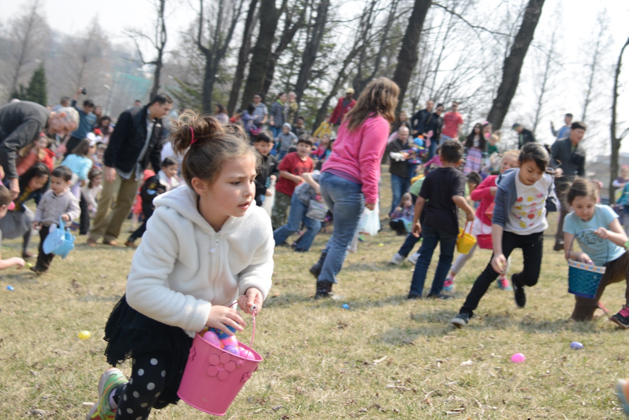 Children search for Easter eggs during the annual Easter egg hunt March 26, 2016, at Osan Air Base, Republic of Korea.  More than 400 children competed in the search for Easter eggs filled with candy. (U.S. Air Force photo by Senior Airman Dillian Bamman/Released)