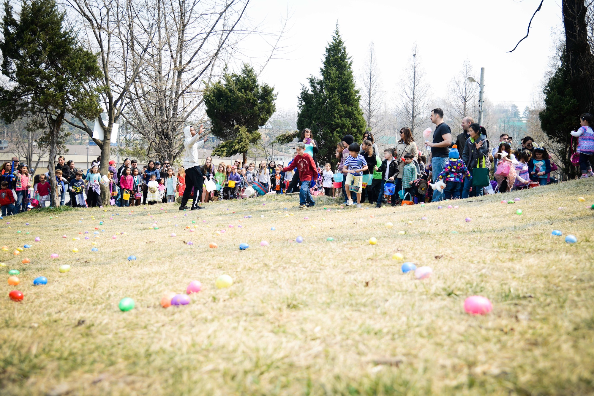 Parents and children standby for the annual Easter egg hunt March 26, 2016, at Osan Air Base, Republic of Korea. Children partook in inflatable rides, bag races and cotton candy during the day’s events. (U.S. Air Force photo by Senior Airman Dillian Bamman/Released)