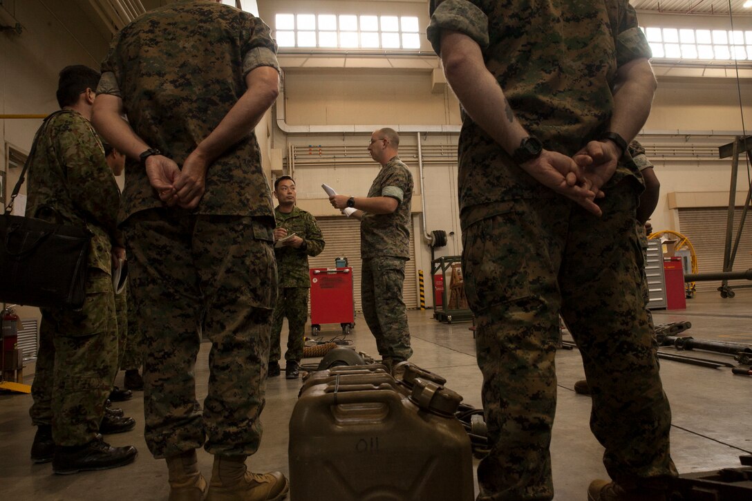 Gunnery Sgt. David Devine explains his real world experience with an Amphibious Assault Vehicle to Japan Ground Self Defense Force Soldiers, March 25, 2016, at Camp Hansen, Okinawa, Japan. “It is great to see the JGSDF and the United States Marine Corps coming together on amphibious operations and capabilities,” said Devine, from Fontana, Calif. Devine is AAV staff noncommissioned officer with Ordnance Maintenance Company, 3rd Maintenance Battalion, Combat Logistics Regiment 35, 3rd Marine Logistics Group, III Marine Expeditionary Force. (U.S. Marine Corps photo by Pfc. Nelson B. Duenas /Released)
