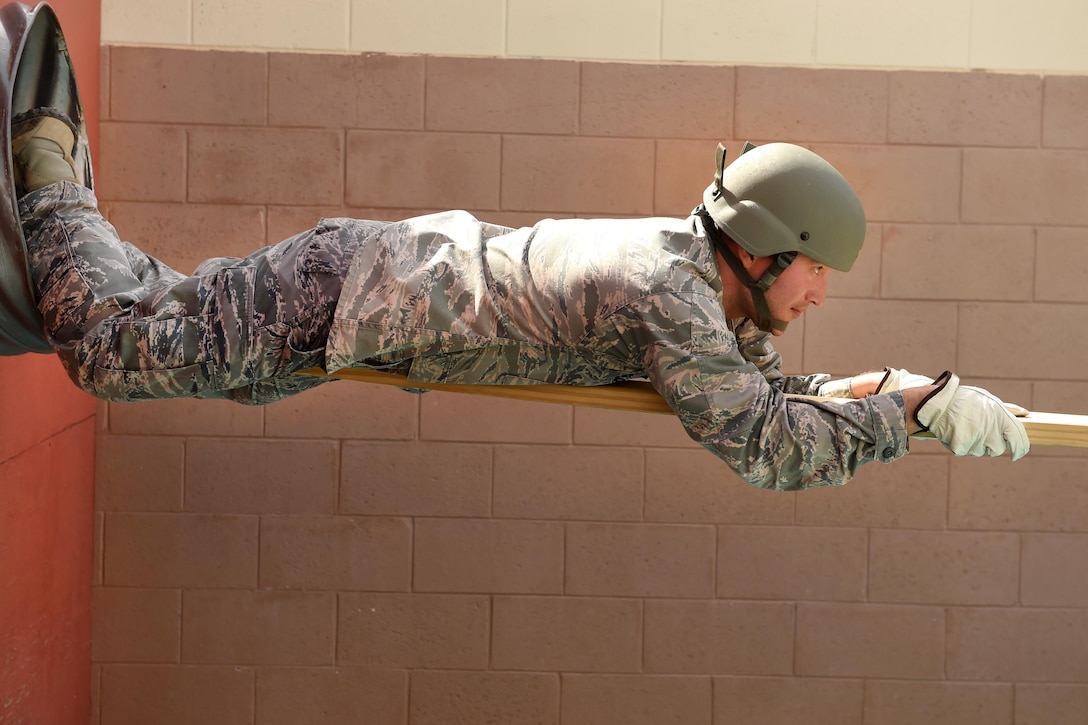 An airman crawls along a wooden plank during Operational Contract Support Joint Exercise 2016 at Fort Bliss, Texas, March 22, 2016. Air Force photo by Staff Sgt. Jonathan Snyder