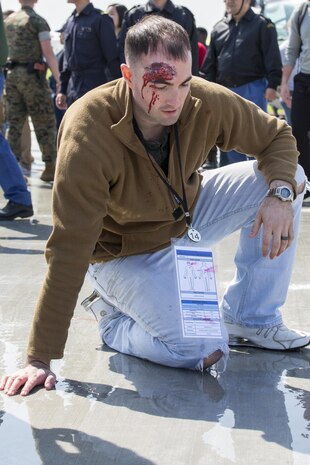 An actor waits to be treated by medical personnel during the Mass Casualty Exercise 2016 at Marine Corps Air Station Iwakuni, Japan, March 23, 2016. Conducted in preparation for the JMSDF/MCAS Iwakuni Friendship Day 2016 Air Show, the exercise simulated a dual aircraft collision where large crowds will be expected. Actors replicated the chaos and panic that people in a real situation may express. First responders guided survivors away from the scene in order for medical teams to properly evacuate all wounded personnel. The exercise helps responders maintain situational readiness and ensure the safety of personnel on the air station. (U.S. Marine Corps photo by Lance Cpl. Aaron Henson/Released)