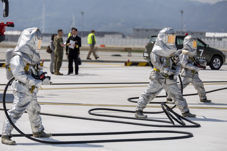 Japan Maritime Self-Defense Force firefighters prepare to extinguish a simulated fire during the Mass Casualty Exercise 2016 at Marine Corps Air Station Iwakuni, Japan, March 23, 2016. Conducted in preparation for the JMSDF/MCAS Iwakuni Friendship Day 2016 Air Show, the exercise simulated a dual aircraft collision where large crowds will be expected. The JMSDF participated in the exercise to enhance bilateral cooperation with U.S. first responders, establish safety measures and maintain situational readiness. (U.S. Marine Corps photo by Lance Cpl. Aaron Henson/Released)