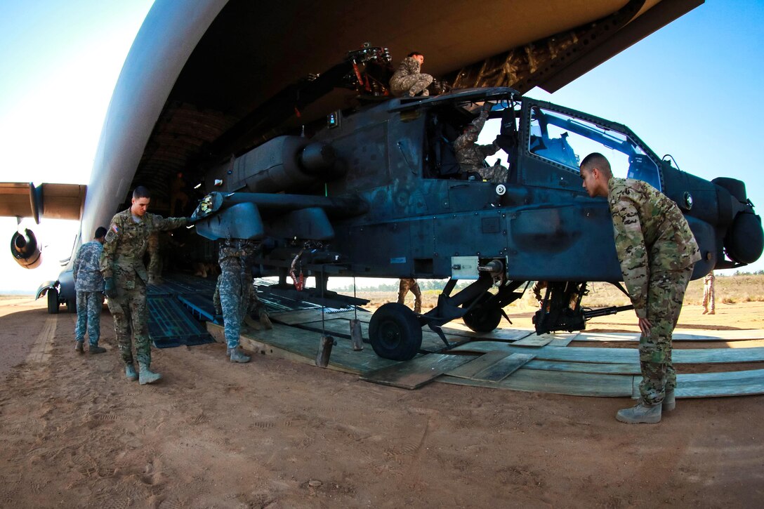 Soldiers offload an AH-64 Apache helicopter from a C-17 Globemaster III at Camp Mackall, N.C., March 17, 2016. The soldiers are assigned to the 82nd Airborne Division’s 82nd 1st Attack Reconnaissance Battalion, 82nd Combat Aviation Brigade. The mission enhances expeditionary readiness with the rapid deployment of the Apache helicopters. Army photo by Capt. Adan Cazarez