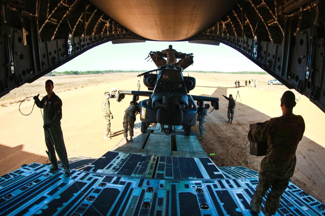 Soldiers work with airmen to offload an AH-64 Apache helicopter from a C-17 Globemaster III at Camp Mackall, N.C., March 17, 2016. Army photo by Capt. Adan Cazarez