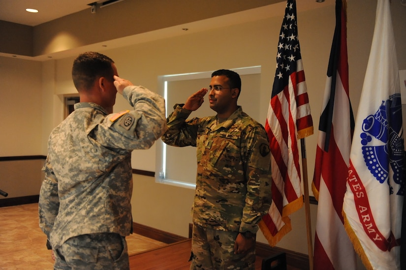First Lt. Anthony Carrillo receives his “First Salute” from his friend Staff Sgt. Julio E. Munoz during a commissioning ceremony at Ramos Hall, Fort Buchanan on March 23. Carrillo direct commissioned into the JAG Corps.