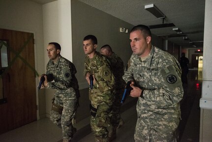 U.S. Army Reserve Sgt. Kevin Moore (left), Spc. Austin Dunaway, and Sgt. Clinton Condo, all military police from the 607th Military Police Battalion, of the 200th MP Command, prepare to clear a hallway during a two-day joint training exercise conducted by the Grand Prairie Police Department in Mansfield, Texas, March 24. More than 15 service members, including Marines from the same Reserve Center, partnered to share and learn police tactics and techniques. (U.S. Army photo by Staff Sgt. Shejal Pulivarti)