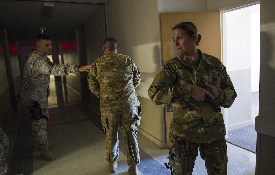 U.S. Army Reserve Sgt. Maj. Nita Harvey, operations sergeant major for the 607th Military Police Battalion, of the 200th MP Command, stands at the low-ready providing rear security for her team in a hallway clearing drill during a two-day joint training exercise conducted by the Grand Prairie Police Department in Mansfield, Texas, March 24. More than 15 service members, including Marines from the same Reserve Center, partnered to share and learn police tactics and techniques. (U.S. Army photo by Staff Sgt. Shejal Pulivarti)