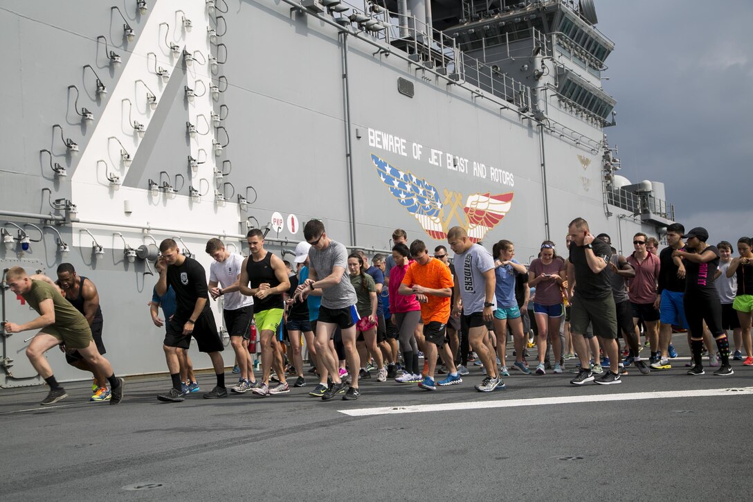 Marines and sailors set off from the starting line for a Women's History Month 5K run aboard the USS Boxer in the Pacific Ocean, March 27, 2016. The Boxer is traveling to the U.S. 5th Fleet area of responsibility during a scheduled deployment. Marine Corps photo by Sgt. Briauna Birl