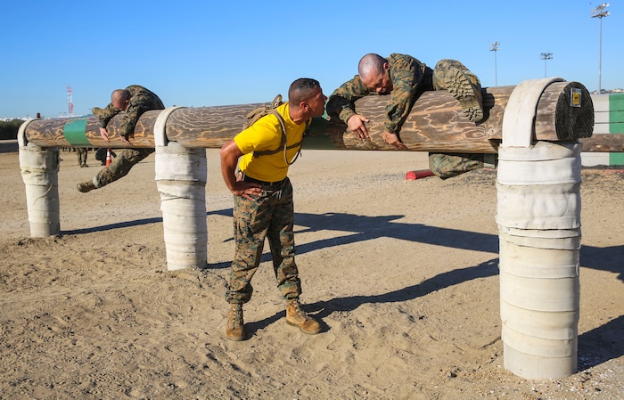 A drill instructor of Fox Company, 2nd Recruit Training Battalion, instructs a recruit to move faster during Obstacle Course II at Marine Corps Recruit Depot San Diego, March 24. If a recruit failed to complete an obstacle the first time, he was sent back to try it again. Annually, more than 17,000 males recruited from the Western Recruiting Region are trained at MCRD San Diego. Fox Company is scheduled to graduate June 3.