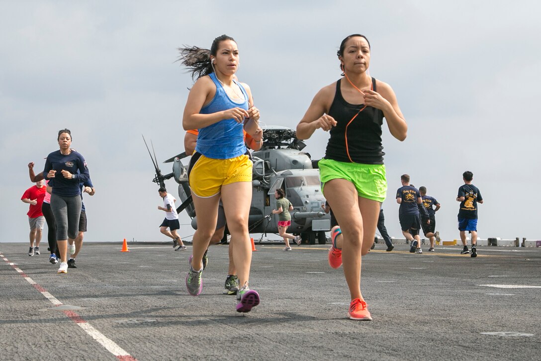 Marine Corps Sgts. Priscilla Castillo and Liliana Sandoval listen to music as they participate in a 5K run for Women's History Month aboard the USS Boxer in the Pacific Ocean, March 27, 2016. Castillo and Sandoval are assigned to the 13th Marine Expeditionary Unit. Marine Corps photo by Sgt. Briauna Birl