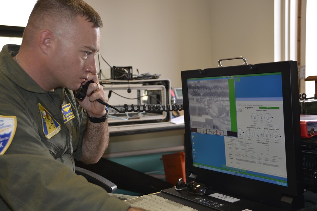 Petty Officer 1st Class Shawn Beal, an acoustics operator with the Naval Air Station Jacksonville Tactical Operations Center, communicates with the P-8A Poseidon aircrew from the ground-based station as he readies for a demonstration of the aircraft’s visual imagery capabilities. The aircraft was here to present a working demonstration to Air Forces Northern leadership about the viability of using imagery feed from the platform during a Defense Support of Civil Authorities  Event. Seven Airmen from Air Forces Northern flew aboard the aircraft during the demonstration to watch onboard operations during the flight. (Air Force  Photo Released/Mary McHale)