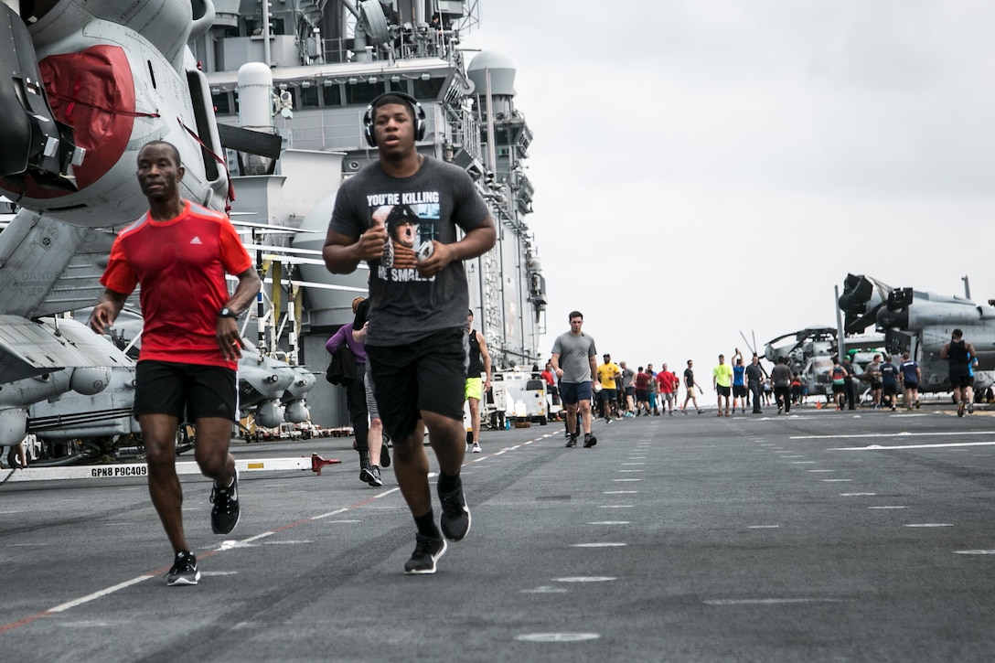 Navy Capt. Keith Moore, left, commander of Amphibious Squadron 1, runs with Marine Corps Cpl. James Rodgers during a Women's History Month 5K run aboard the USS Boxer in the Pacific Ocean, March 27, 2016. Marine Corps photo by Sgt. Briauna Birl