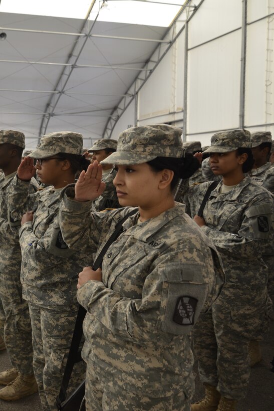 Soldiers from the 392nd ESB salute the American flag during the playing of the national anthem at a deployment ceremony on March 26, 2016 at Fort Meade, Md.