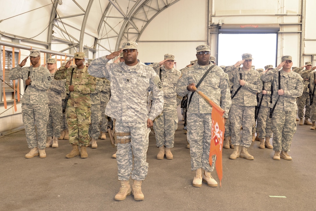 Soldiers from the 392nd ESB salute the American flag during the playing of the national anthem at a deployment ceremony on March 26, 2016 at Fort Meade, Md.