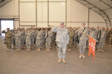 Soldiers from Bravo Company, 392nd ESB salute the American flag during the playing of the national anthem at a deployment ceremony on March 26, 2016 at Fort Meade, Md.