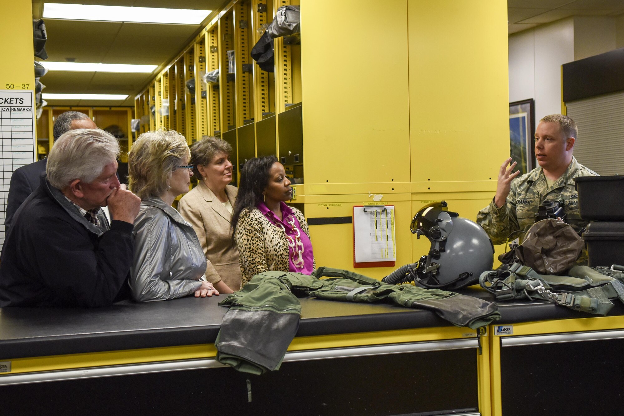 Tech. Sgt. Michael Cramer (right), 4th Operations Support Squadron aircrew flight equipment technician, explains the different equipment aircrew wear to a tour group, March 25, 2016, at Seymour Johnson Air Force Base, North Carolina. Members from the community received a tour of the squadron and watched aircraft launch on the flightline. (U.S. Air Force photo/Airman Shawna L. Keyes)  
