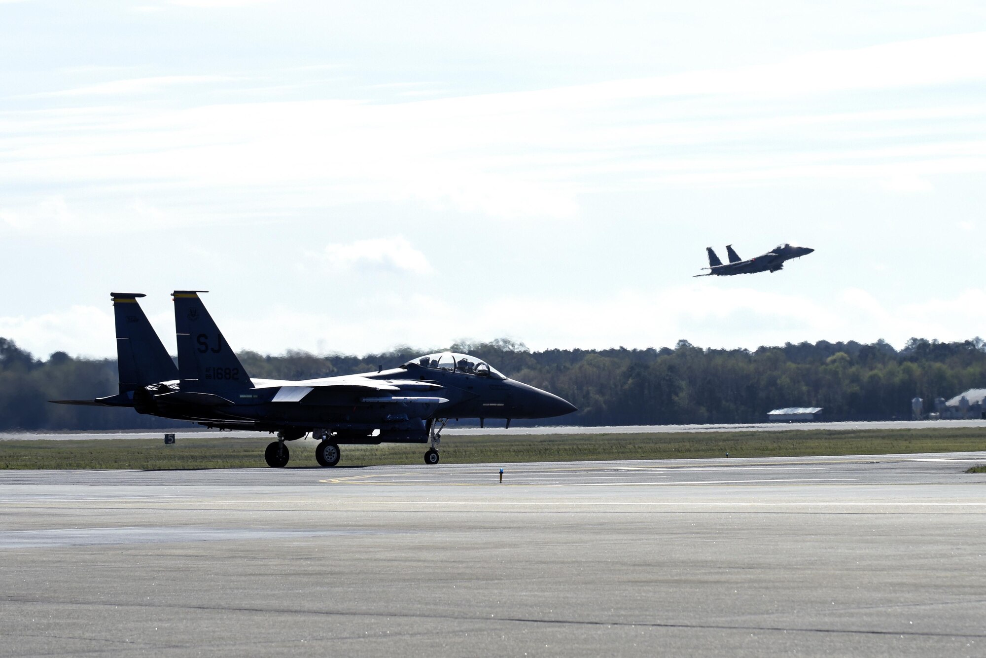An F-15E Strike Eagle from the 336th Fighter Squadron taxis down the runway while another F-15E takes off for Razor Talon, March 25, 2016, at Seymour Johnson Air Force Base, North Carolina. More than 10 aircraft from multiple bases participated, including KC-135R Stratotankers and E-3Sentries. (U.S. Air Force photo/Airman Shawna L. Keyes) 