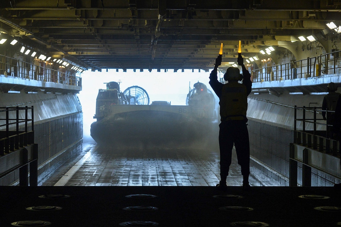 Navy Seaman Damien Galarza directs a landing craft air cushion 85  out of the well deck of the amphibious assault ship USS Bataan in Onslow Bay, N.C., March 21, 2016. The Navy uses such vessels to transport equipment, cargo and personnel. Galarza is a boatswain's mate. Navy photo by Petty Officer 3rd Class Mutis A. Capizzi
