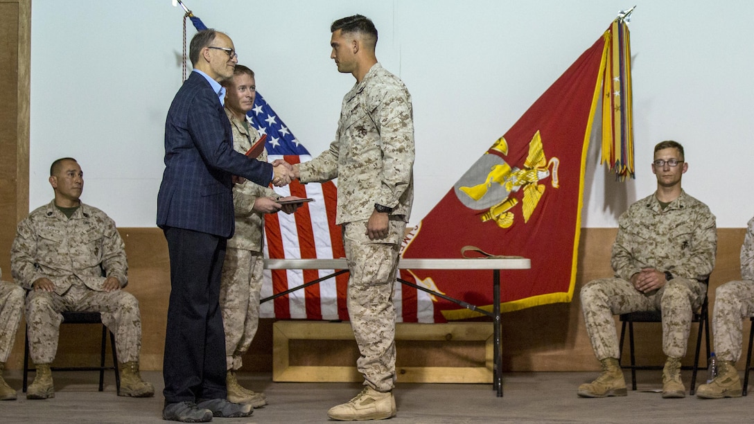 Ambassador Douglas A. Silliman, second from left, the U.S. Ambassador to Kuwait, along with U.S. Marine Col. William F. McCollough, commanding officer of Special Purpose Marine Air Ground Task Force-Crisis Response-Central Command, present the Corporals Course graduates with their diplomas in Kuwait on March 25, 2016. The corporals’ leadership program is designed to provide instruction for tasks developed in accordance with Marine Corps Order 1510.90, Individual Training Standards. Corporals Course is a professional military education requirement for all corporals to complete in order to be qualified for promotion.