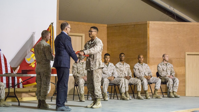 Ambassador Douglas A. Silliman, second from left, the U.S. Ambassador to Kuwait, along with U.S. Marine Col. William F. McCollough, commanding officer of Special Purpose Marine Air Ground Task Force-Crisis Response-Central Command, present the Corporals Course graduates with their diplomas in Kuwait on March 25, 2016. The corporals’ leadership program is designed to provide instruction for tasks developed in accordance with Marine Corps Order 1510.90, Individual Training Standards. Corporals Course is a professional military education requirement for all corporals to complete in order to be qualified for promotion.