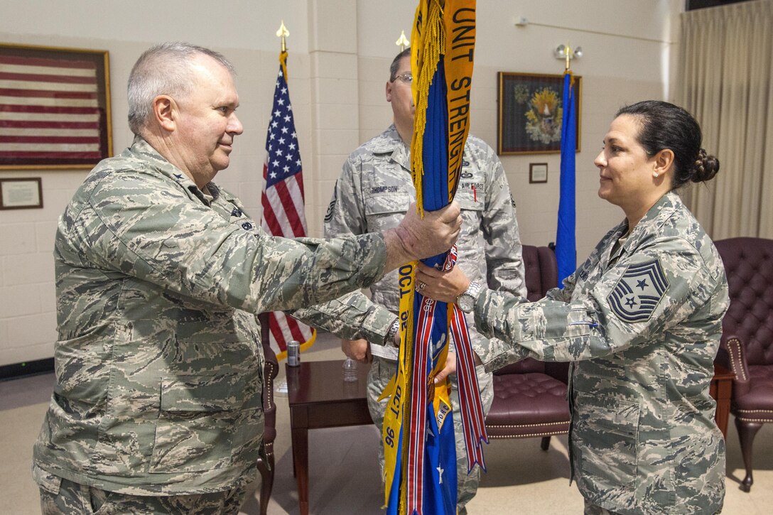 Air Force Brig. Gen. Michael L. Cunniff, left, the adjutant general of New Jersey, passes the New Jersey Joint Force Headquarters guidon to incoming New Jersey State Command Chief Master Sgt. Janeen M. Fillari during a change-of-responsibility ceremony at Joint Base McGuire-Dix-Lakehurst, N.J., March 19, 2016. Fillari is the first woman to serve as the command chief master sergeant for the New Jersey Air National Guard. New Jersey National Guard photo by Air Force Master Sgt. Mark C. Olsen