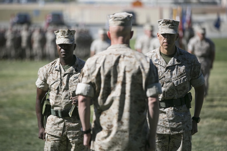 Sgt. Maj. Edward Zapata, oncoming sergeant major, and Sgt. Maj. Rodney Lane, outgoing sergeant major, 7th Marine Regiment, stand in front of Col. William Vivian, commanding officer, 7th Marine Regiment, through the exchange of the non-commissioned officer sword during the regiment’s relief and appointment ceremony at Lance Cpl. Torrey L. Gray field, March 18, 2016.(Official Marine Corps Photo by Cpl. Julio McGraw/Released)