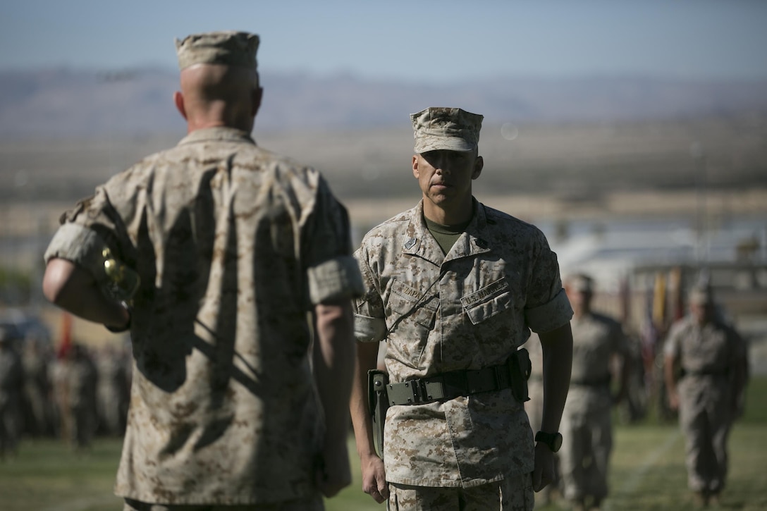 Sgt. Maj. Edward Zapata, regimental sergeant major, prepares to take the Non-Commissioned Officers’ sword from Col. William Vivian, commanding officer, 7th Marine Regiment, through the exchange of the  NCO sword during the regiment’s relief and appointment ceremony at Lance Cpl. Torrey L. Gray field, March 18, 2016. (Official Marine Corps Photo by Cpl. Julio McGraw/Released)